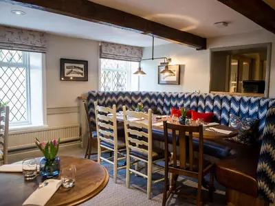 a dining room with wooden tables and chairs at The Millstone, Mellor in Blackburn