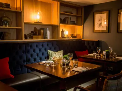 a dining room with two tables and a bench at The Millstone, Mellor in Blackburn
