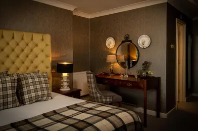 a bedroom with a bed and a desk and a mirror at The Millstone, Mellor in Blackburn