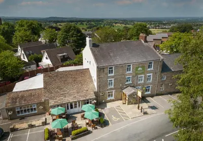 an overhead view of a building with tables and umbrellas at The Millstone, Mellor in Blackburn