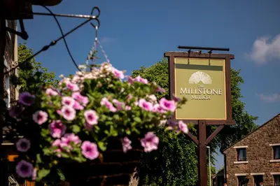 a sign for a millhouse kitchen with pink flowers at The Millstone, Mellor in Blackburn