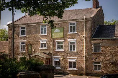 an old brick building with a sign on it at The Millstone, Mellor in Blackburn