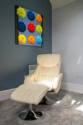 a white chair in a room with a painting at The Castle Collection - 42 Castle Street in Liverpool