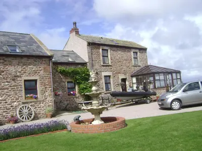 a stone house with a fountain in front of it at Cottage - Sleeps 5 - Hot Tub - Garden - Parking in Lancaster