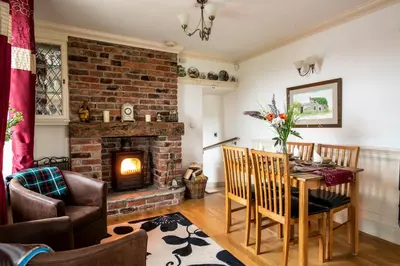 a living room with a table and a fireplace at Cottage - Sleeps 5 - Hot Tub - Garden - Parking in Lancaster