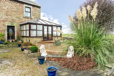 a house with a garden with plants in front of it at Cottage - Sleeps 5 - Hot Tub - Garden - Parking in Lancaster