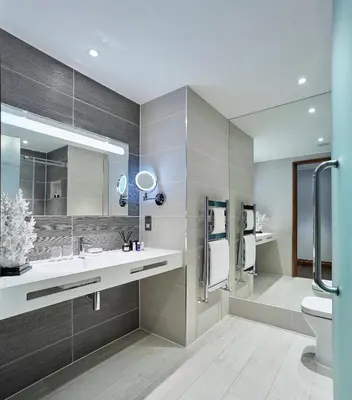 a bathroom with a sink and a toilet and a mirror at The Hotel at Mill Farm in Kirkham