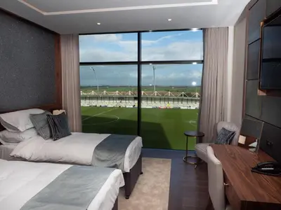 a hotel room with two beds and a large window at The Hotel at Mill Farm in Kirkham