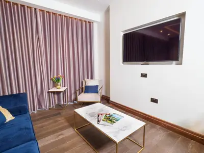 a living room with a blue couch and a large window at The Hotel at Mill Farm in Kirkham