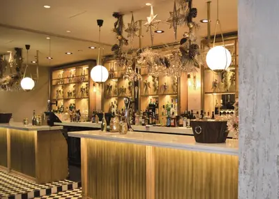 a bar in a restaurant with a counter and lights at The Hotel at Mill Farm in Kirkham