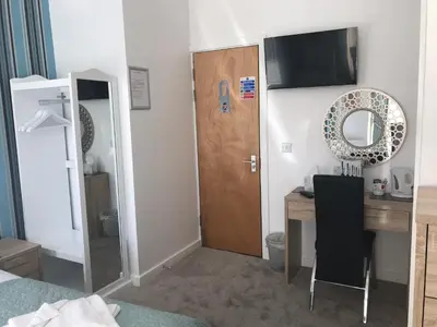 a bedroom with a desk and a wooden door at Four Seasons Guest House in Blackpool