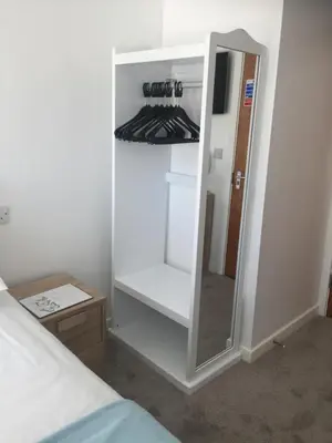 a white cabinet with a mirror in a bedroom at Four Seasons Guest House in Blackpool