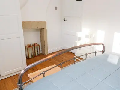 a bedroom with a staircase with a bed and a fireplace at 3 Poole End in Clitheroe