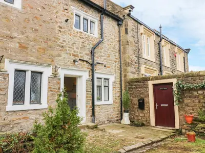 an old stone house with a red door at 3 Poole End in Clitheroe