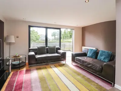 a living room with leather furniture and a large window at Underfell in Carnforth
