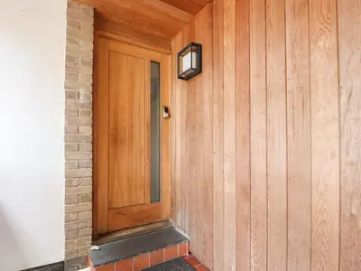 a wooden door with a light on a wall at Underfell in Carnforth