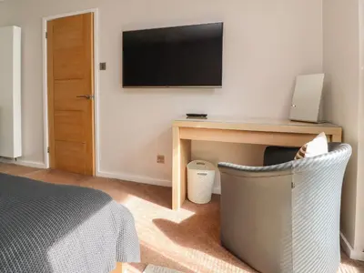 a bedroom with a bed and a desk with a television at Underfell in Carnforth