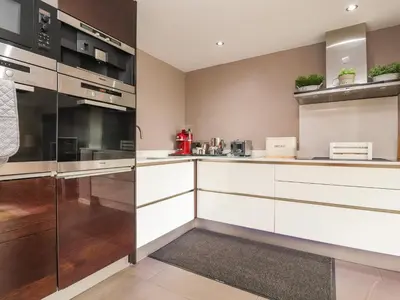 a kitchen with white cabinets and stainless steel appliances at Underfell in Carnforth
