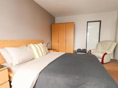 a bedroom with a large bed and a chair at Underfell in Carnforth