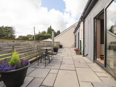 a patio with chairs and flowers on a building at Underfell in Carnforth