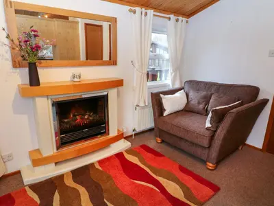 a living room with a couch and a fireplace at The Cedars in Carnforth