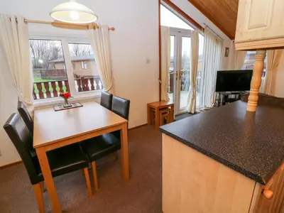 a kitchen with a table and chairs and a counter top at The Cedars in Carnforth
