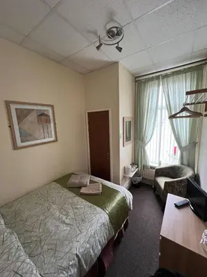 a hotel room with a bed and a desk at Tudor Rose Hotel in Blackpool