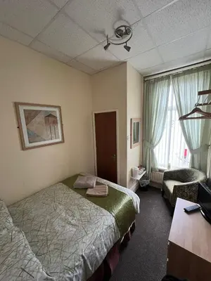a hotel room with two beds and a window at Tudor Rose Hotel in Blackpool