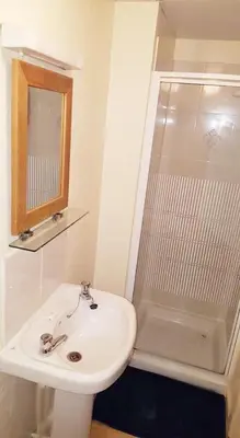 a white bathroom with a sink and a shower at Tudor Rose Hotel in Blackpool