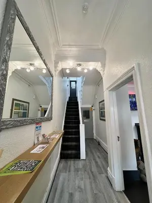 a hallway with a mirror and a staircase in a room at Tudor Rose Hotel in Blackpool