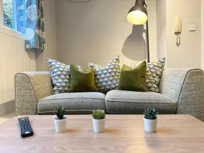 a living room with a couch with pillows and a table at Warehouse Apartments 1Bed Sleeps 2 Pets Welcome in Ulverston