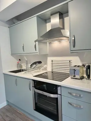 a kitchen with white cabinets and a stove top oven at Warehouse Apartments 1Bed Sleeps 2 Pets Welcome in Ulverston