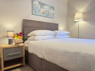 a bedroom with a large bed and a nightstand with a bed sidx sidx sidx at Warehouse Apartments 1Bed Sleeps 2 Pets Welcome in Ulverston