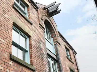 an arched window on the side of a brick building at Warehouse Apartments 1Bed Sleeps 2 Pets Welcome in Ulverston