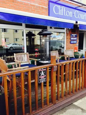 a restaurant with two chairs and a sign on a porch at Clifton Court Hotel in Blackpool