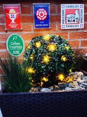 a planter with lights and signs on a brick wall at Clifton Court Hotel in Blackpool