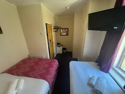 a room with two beds and a flat screen tv at The Shores Hotel, Central Blackpool in Blackpool