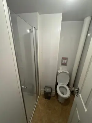 a small bathroom with a toilet and a shower at The Shores Hotel, Central Blackpool in Blackpool