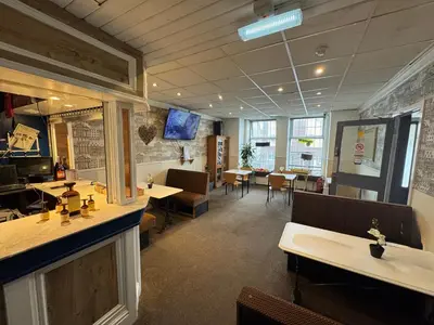 a restaurant with a bar and tables and chairs at The Shores Hotel, Central Blackpool in Blackpool
