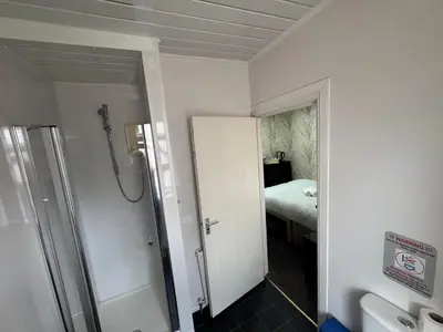 a bathroom with a shower and a door to a bedroom at The Shores Hotel, Central Blackpool in Blackpool