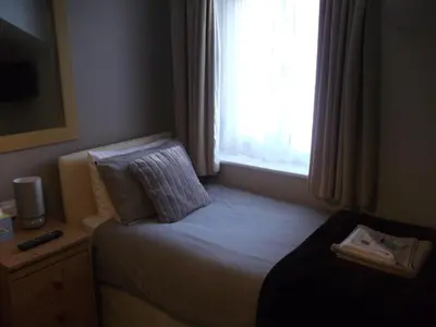 a small bed in a room with a window at Atlantis Hotel in Blackpool