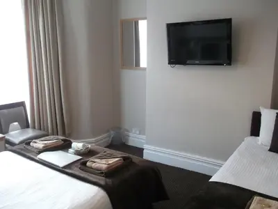 a hotel room with two beds and a flat screen tv at Atlantis Hotel in Blackpool