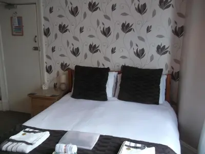 a bedroom with a white bed with black pillows at Atlantis Hotel in Blackpool