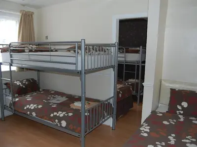 a room with two bunk beds and a couch at Atlantis Hotel in Blackpool