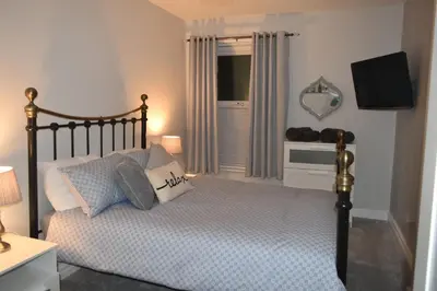 a bedroom with a bed with pillows and a television at Pleasure Beach House in Blackpool