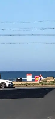a person taking a picture of a car on a road at Pleasure Beach House in Blackpool