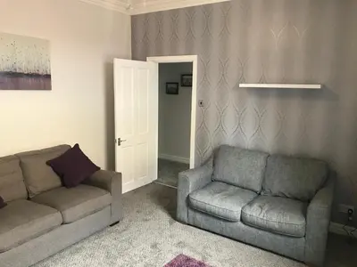 a living room with a couch and a chair at Pleasure Beach House in Blackpool