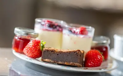 a plate of food with a piece of cake and strawberries at Hotel Sheraton in Blackpool