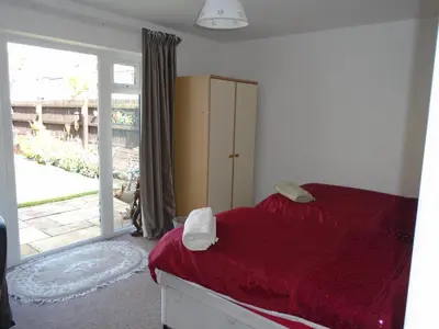 a bedroom with a bed with red sheets and a window at TEA in Liverpool - Private - Quiet - Ground Floor - En-suite - Walk-in-shower in Liverpool