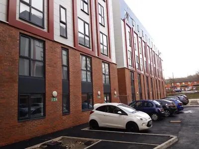 a white car parked in a parking lot next to a building at Fox Street Delight in Liverpool